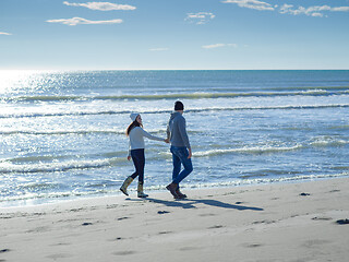 Image showing Loving young couple on a beach at autumn sunny day