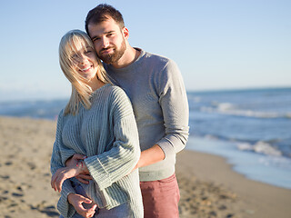 Image showing Loving young couple on a beach at autumn sunny day