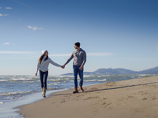 Image showing Loving young couple on a beach at autumn sunny day