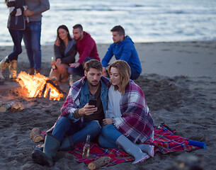 Image showing Couple enjoying bonfire with friends on beach