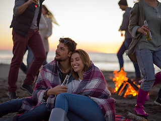 Image showing Couple enjoying with friends at sunset on the beach