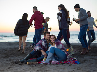 Image showing Couple enjoying with friends at sunset on the beach