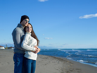 Image showing Loving young couple on a beach at autumn sunny day