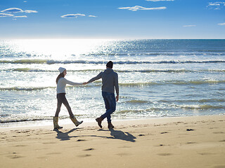 Image showing Loving young couple on a beach at autumn sunny day