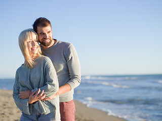 Image showing Loving young couple on a beach at autumn sunny day