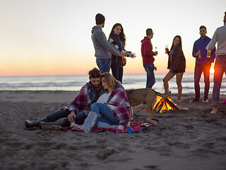 Image showing Couple enjoying with friends at sunset on the beach