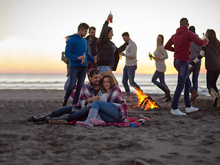 Image showing Couple enjoying with friends at sunset on the beach