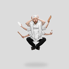 Image showing Cooker, chef, baker in uniform multitask like shiva isolated on gray studio background