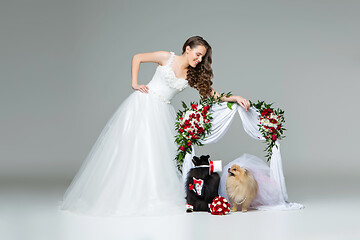 Image showing bride girl with dog wedding couple under flower arch