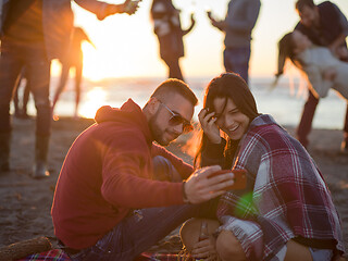 Image showing Couple enjoying bonfire with friends on beach