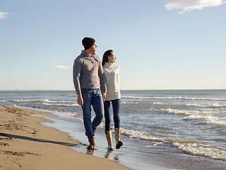 Image showing Loving young couple on a beach at autumn sunny day