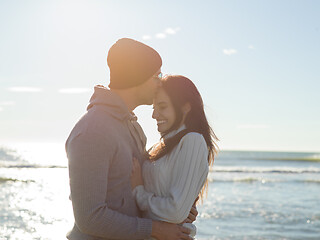 Image showing Loving young couple on a beach at autumn sunny day