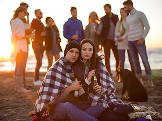 Image showing Couple enjoying with friends at sunset on the beach