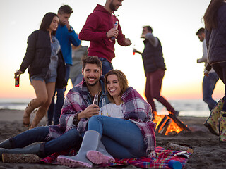 Image showing Couple enjoying with friends at sunset on the beach