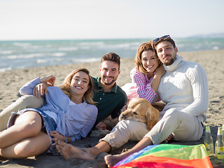 Image showing Group of friends having fun on beach during autumn day