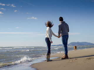 Image showing Loving young couple on a beach at autumn sunny day