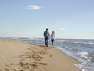 Image showing Loving young couple on a beach at autumn sunny day