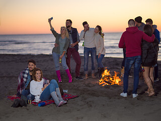 Image showing Couple enjoying with friends at sunset on the beach