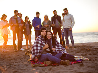 Image showing Couple enjoying with friends at sunset on the beach