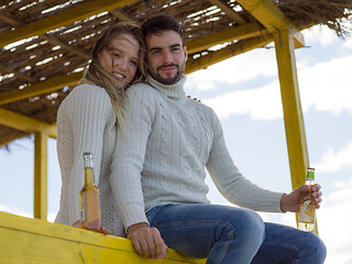 Image showing young couple drinking beer together at the beach