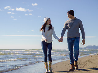 Image showing Loving young couple on a beach at autumn sunny day