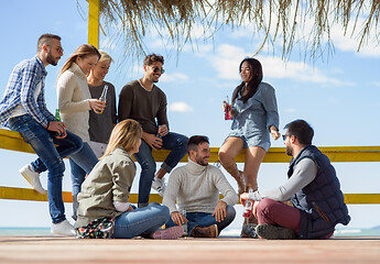 Image showing Group of friends having fun on autumn day at beach