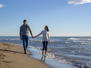 Image showing Loving young couple on a beach at autumn sunny day