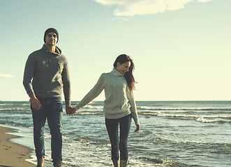 Image showing Loving young couple on a beach at autumn sunny day