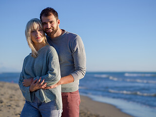 Image showing Loving young couple on a beach at autumn sunny day