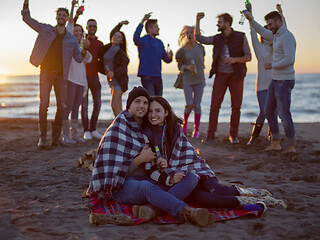 Image showing Couple enjoying with friends at sunset on the beach