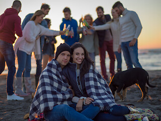 Image showing Couple enjoying with friends at sunset on the beach