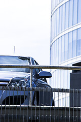 Image showing Front view of car with skyscraper in background