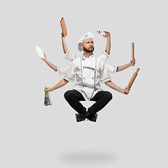 Image showing Cooker, chef, baker in uniform multitask like shiva isolated on gray studio background