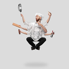 Image showing Cooker, chef, baker in uniform multitask like shiva isolated on gray studio background