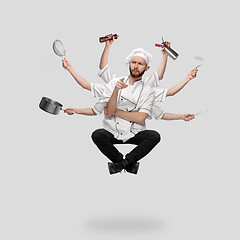 Image showing Cooker, chef, baker in uniform multitask like shiva isolated on gray studio background