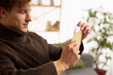 Image showing Man opening, recieving greeting card for New Year and Christmas 2021 from friends or family