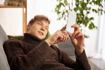 Image showing Man reading message, greetings for New Year and Christmas 2021 from friends or family with his cellphone