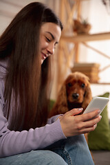 Image showing Woman reading message, greetings for New Year and Christmas 2021 from friends or family with her cellphone