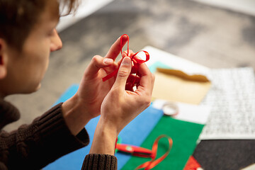 Image showing Man making greeting card for New Year and Christmas 2021 for friends or family, scrap booking, DIY