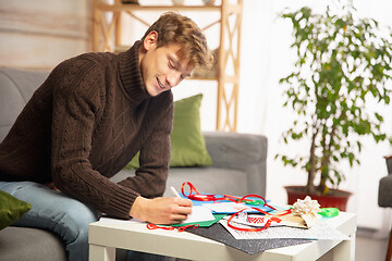 Image showing Man making greeting card for New Year and Christmas 2021 for friends or family, scrap booking, DIY