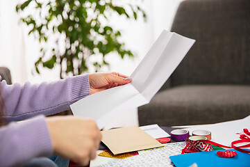 Image showing Woman opening, recieving greeting card for New Year and Christmas 2021 from friends or family