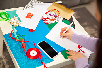 Image showing Woman making greeting card for New Year and Christmas 2021 for friends or family, scrap booking, DIY