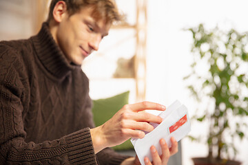 Image showing Man opening, recieving greeting card for New Year and Christmas 2021 from friends or family