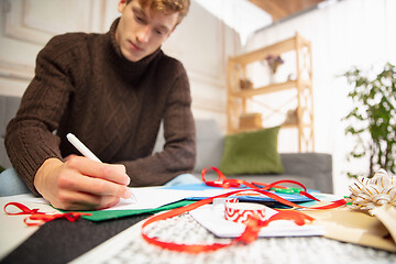 Image showing Man making greeting card for New Year and Christmas 2021 for friends or family, scrap booking, DIY