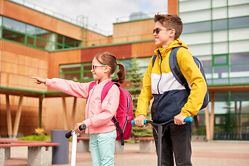 Image showing happy school children with backpacks and scooters