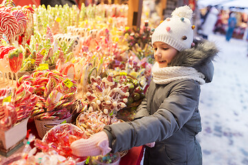 Image showing little girl choosing sweets at christmas market