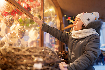 Image showing girl choosing christmas decorations at market
