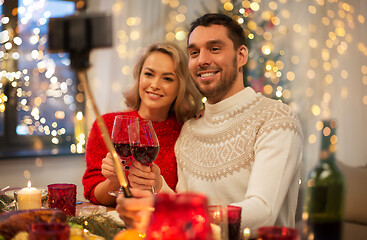 Image showing couple taking picture by selfie stick at christmas