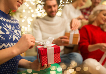 Image showing close up of friends opening christmas gifts