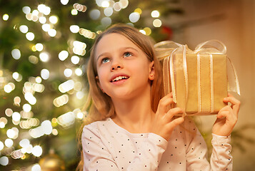 Image showing smiling girl with christmas gift at home